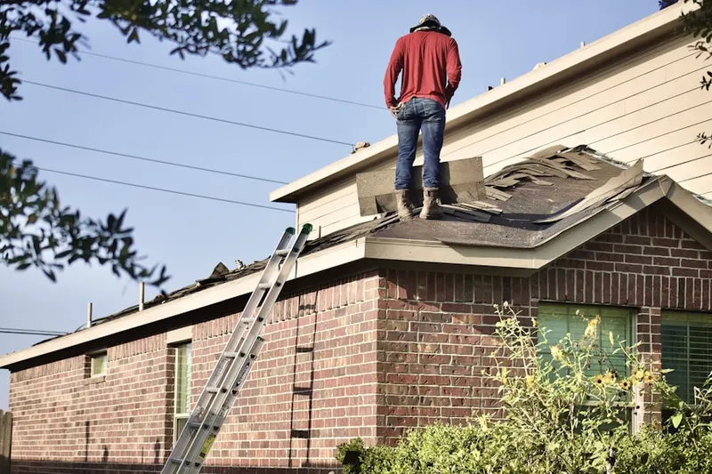 Professional roofer working on a residential roof in Amboy Avenue